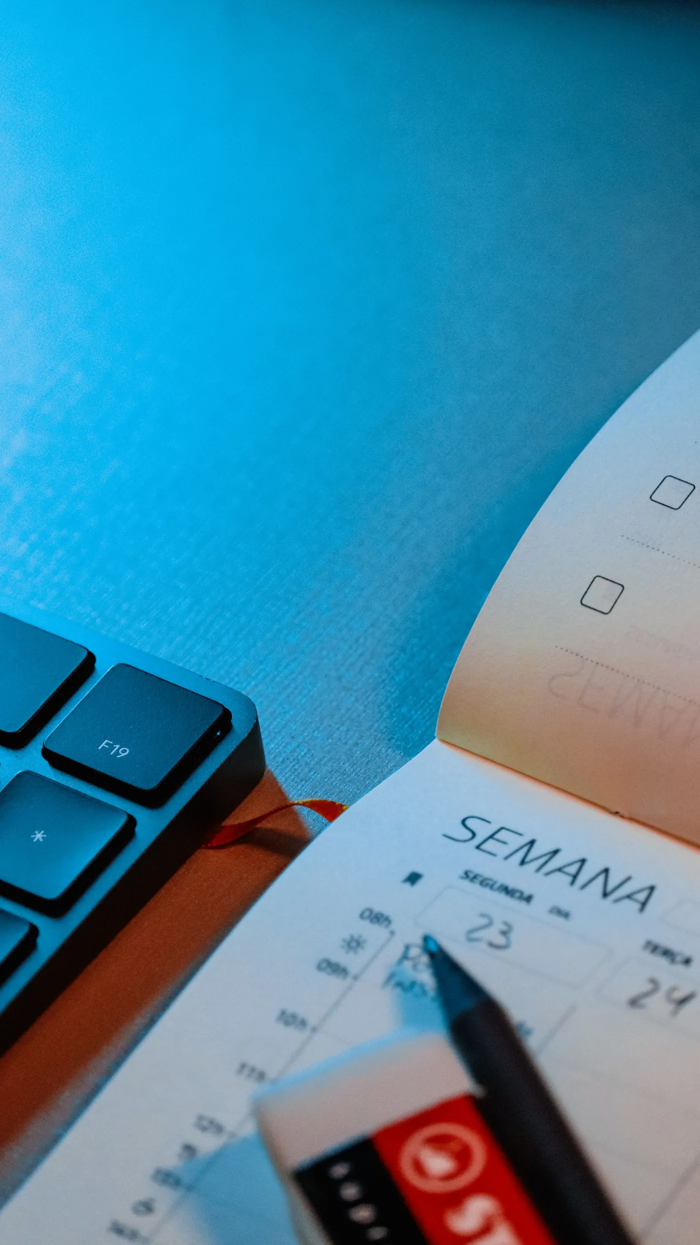Agenda semanal junto a un teclado en un escritorio